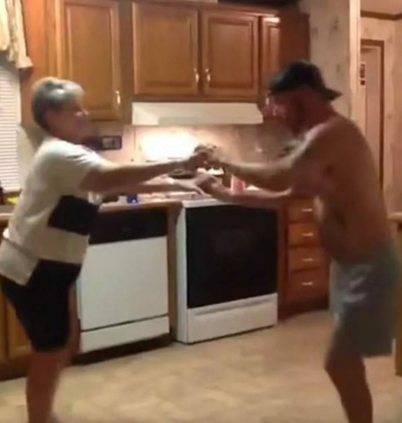 Сын стал приставать к маме. Мать танцует с сыном на кухне.